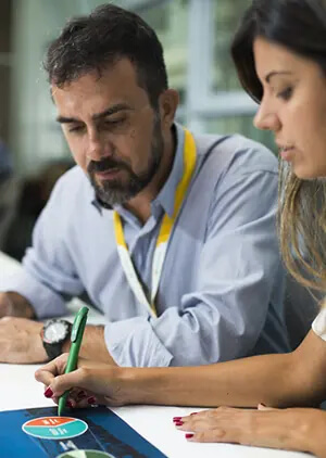 homem e mulher analisando gráfico impresso