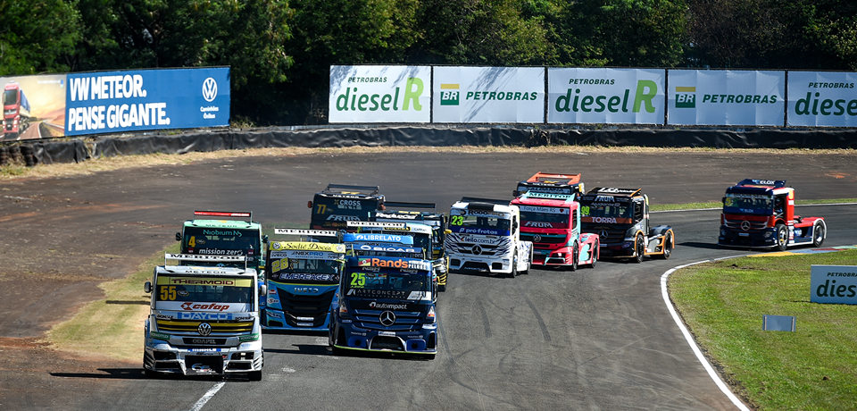 caminhões em pista de corrida com placa de diesel R e Petrobras