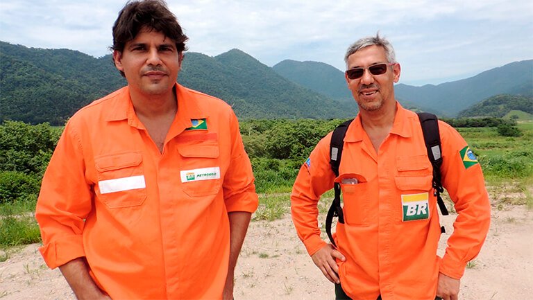 O engenheiro Fred e o biólogo Jorge, ambos lado a lado com o uniforme da Petrobras.