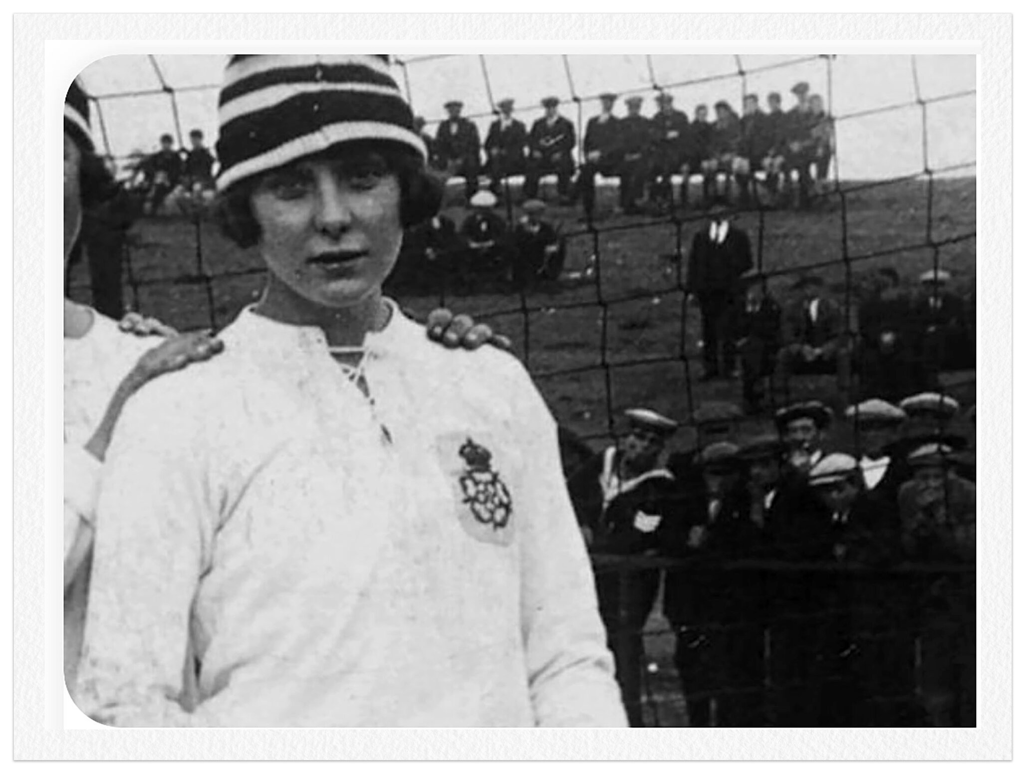 Fotografia antiga, em preto e branco, da jogadora Lily Parr usando uniforme branco de manga comprida.